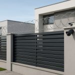 A modern fence with barbed wire and a security camera, emphasizing property security and value.